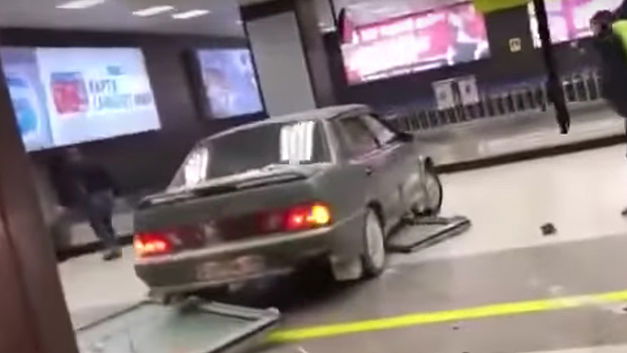 Dronkenman rijdt met de auto de luchthaven binnen