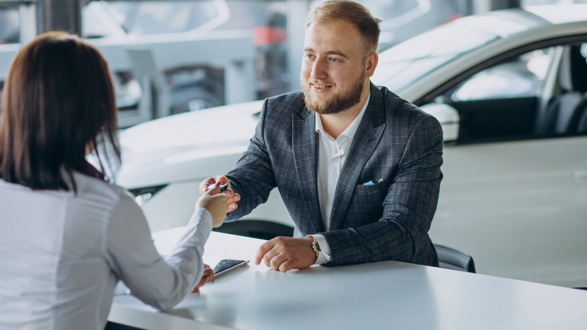 man-with-sales-woman-car-showroom
